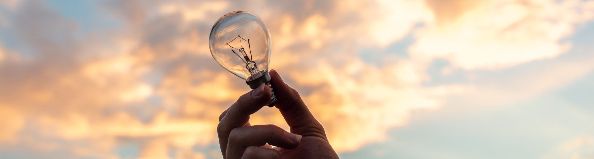 Female hand holding for a lighglobe at sunrise